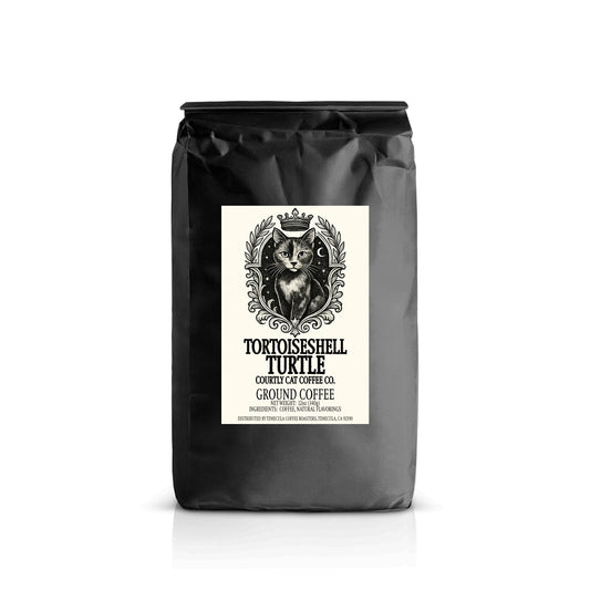 Sophisticated black coffee bag with a label featuring an illustration of a tortoiseshell breed cat with a crown in a celestial royal crest and text on a white background.